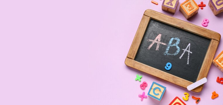 Applied behavior analysis therapy, aba for autism spectrum disorder with wooden alphabet blocks and chalkboard on a light purple background