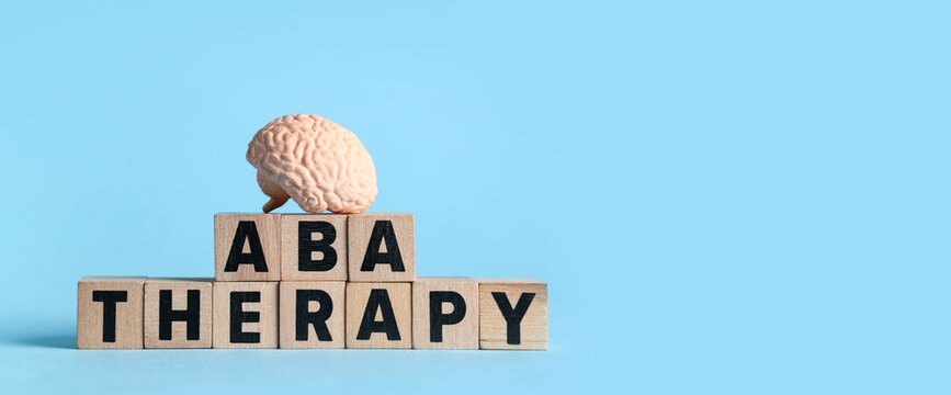 Aba therapy and autism support, applied behavior analysis with human brain model on wooden blocks for mental health and developmental education