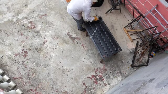 Aerial Drone View of Welding Sparks Falling on Metal Sheet in Outdoor Workshop