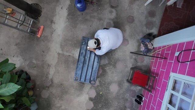 High Angle Aerial View of Worker Opening Paint Can and Coating Metal Sheet