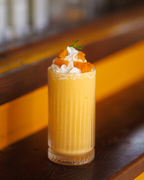 Mango Smoothie with Whipped Cream and Fruit Topping Close-Up