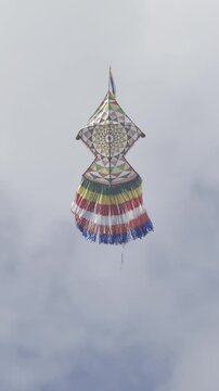 Colorful kite dancing gracefully in the cloudy blue sky