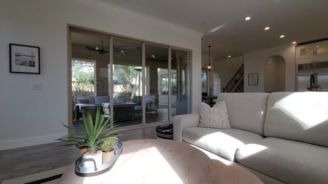 Bright modern living room with sunlit seating and open kitchen