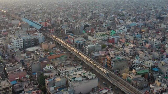 Aerial view residential buildings in crowded Govandi neighbourhood in suburbs of New Delhi India, population growth, poverty and overpopulation concept. Mumbai. house home. transportation Metro train