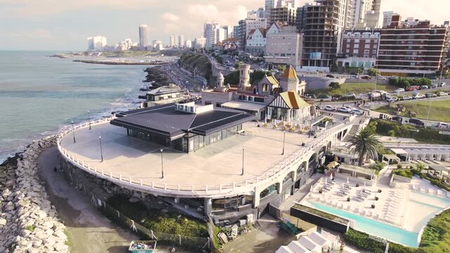4K drone aerial view of Torre&oacute;n del Monje in Mar del Plata, Argentina. The iconic coastal landmark stands above the Atlantic waterfront with the city&rsquo;s urban skyline stretching behind it.
