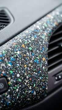 Recycled plastic dashboard panel installed in modern car interior showing colorful sustainable material texture