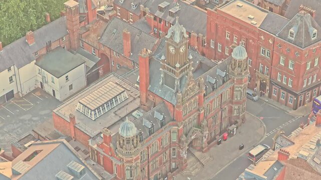 York Magistrates' Court rises above Clifford Street in York, England, with ornate red brickwork, clock tower, roof lanterns and historic civic architecture, establishing aerial shot.