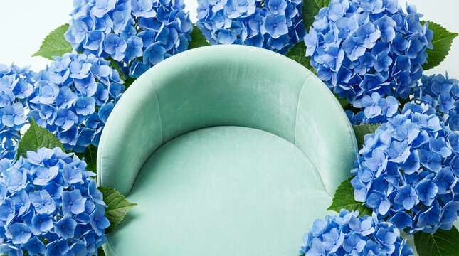 Beautiful top-down flat lay perspective photography of a Mint Green soft velvet curved platform podium surrounded by vibrant blue hydrangeas under bright high-key studio lighting. 
