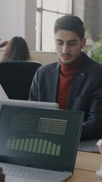 Young businessman working in busy office indoors