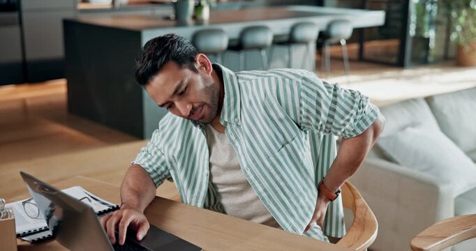 Man, laptop and remote work in apartment with back pain, bad posture and stress from job challenge. Tired, person or freelancer in home with spine injury, uncomfortable chair or computer with burnout
