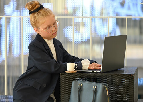 A little girl is concentrating on her laptop