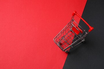 Photo of small silver shopping cart on two-tone background, top view. Shopping concept. Space for text © Sunlight