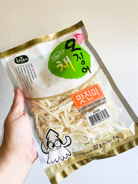 A hand holding a bag of seasoned and shredded squid snack - Auburn WA USA - August,21 2026