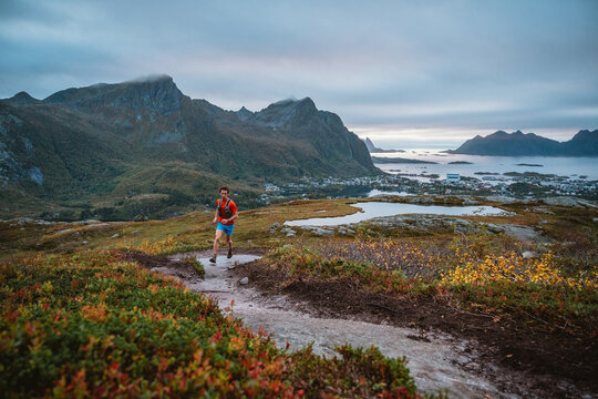 Man trail running on a mountain in Lofoten Norway