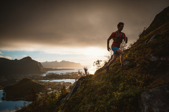 Man trail runs up steep mountain at sunrise