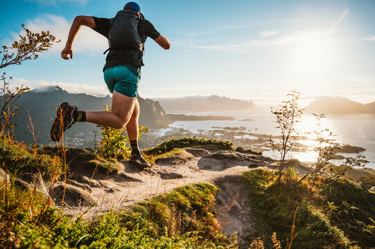 Man trail running on mountain top in Lofoten Norway