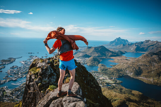 Trail runner putting on a wind shell during a trail run