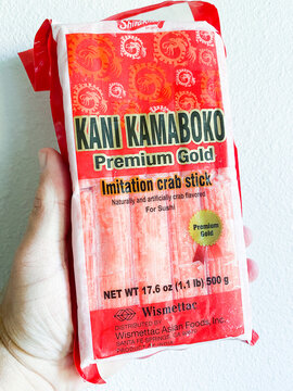 A hand holding a package of Kani Kamaboko Premium Gold imitation crab sticks for sushi. - Auburn WA USA - August,21 2026