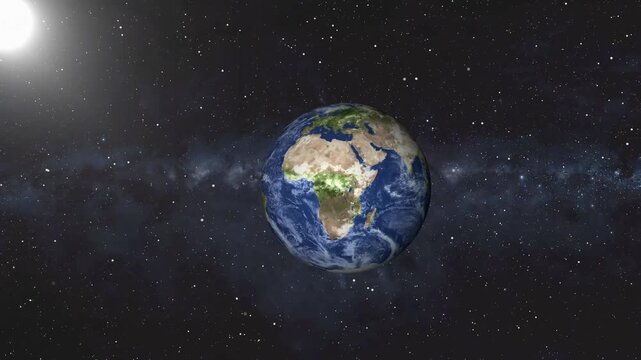 Glowing planet Earth rotates gracefully beside a bright blazing sun. Deep space starlight illuminates this glowing planet Earth. Cosmic solar system views frame the glowing planet Earth.