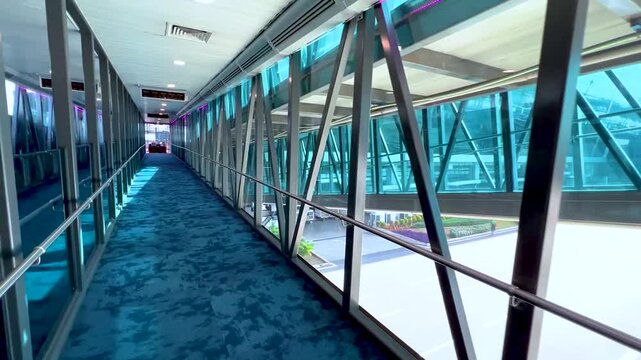 Modern Glass Airport Skywalk Terminal Corridor Walkway Interior Motion Boarding Gate Jet Bridge Passageway Architecture Aviation Travel Transport Passenger Concept 4K Real Time Stock Footage