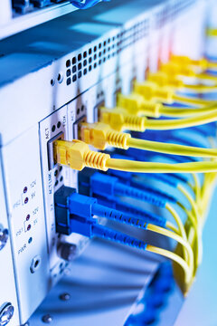 Fiber Optic cables connected to an optic ports and Network cables connected to ethernet ports and UTP Network