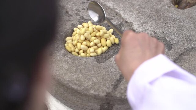 전통 방식 두부 만들기 맷돌 콩 갈기 순두부 손두부 대두 황태 콩즙 전통 방식 민속촌 초가가옥 전통문화 조리과정 수제 두부 정성 식재료 한국전통 요리 디테일 클로즈업 건강식 향토음식 장인 정신 노하우 농촌풍경