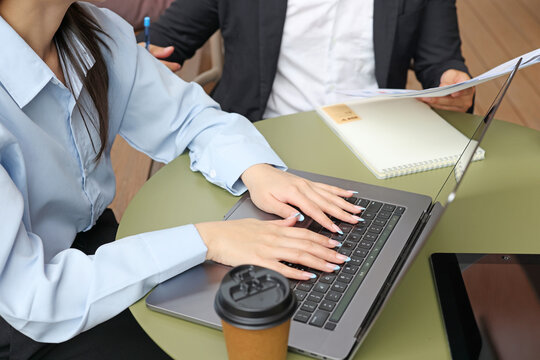 Business Professionals Working on Laptop and Reviewing Documents at Outdoor Table