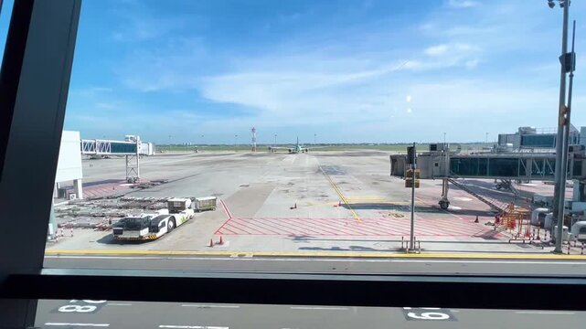 Empty Airport Apron Tarmac and Passenger Jet Bridge View Through Gate Glass Window Bright Sunny Day Aircraft Parking Gate Operations Aviation Transportation Industry Concept Wide Angle Shot