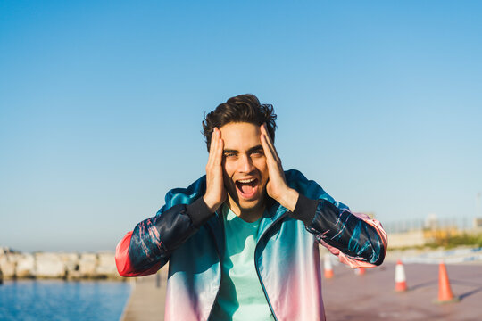 Surprised man screaming for joy with hands on head