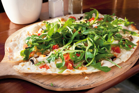 Close up of tarte flambee with rocket and Gorgonzola cheese
