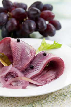 Herring in sherry vinegar with onions on plate, close up