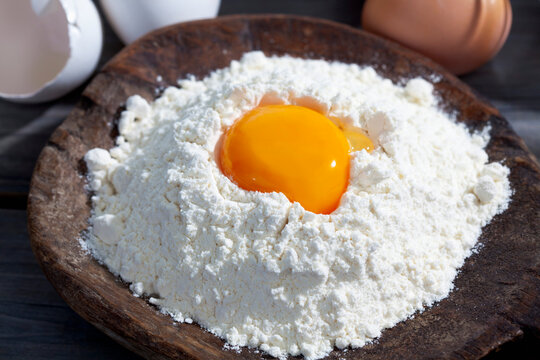 Wooden spoon of flour with egg yolk