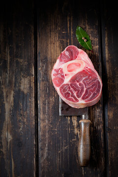 Raw beef shank with bay leaves and allspice on cleaver