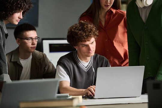 Group of university students study together on a laptop indoors