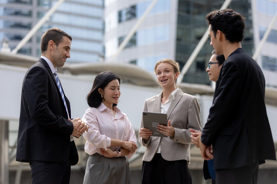 Business teamwork concept. diverse professional colleagues discussing ideas and sharing tablet outdoors in corporate district. teamwork, business, team, collaboration, tablet.