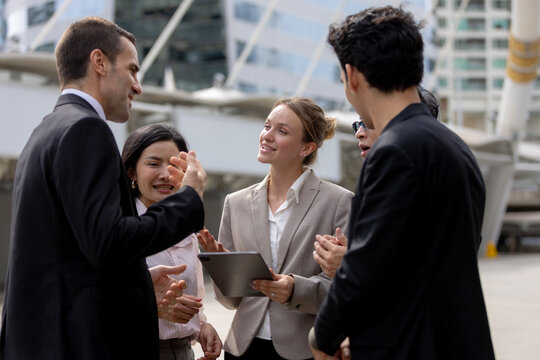Business teamwork concept. diverse professional colleagues discussing ideas and sharing tablet outdoors in corporate district. teamwork, business, team, collaboration, tablet.