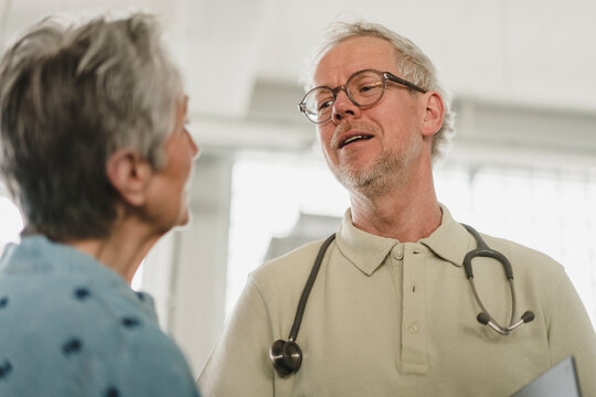 Male doctor talks to female patient during medical consultation