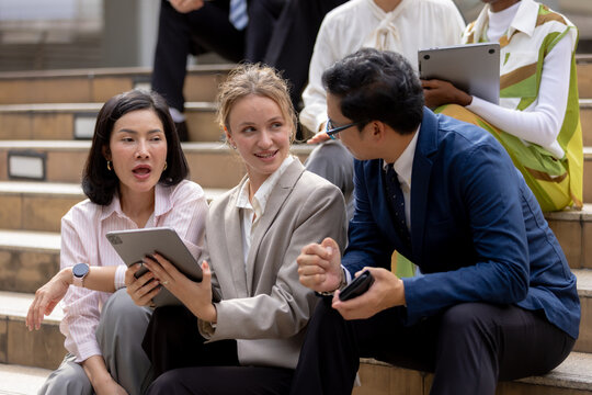 Business teamwork concept, Businessperson brainstorm colleagues discussing ideas and using tablets together while sitting outdoors in corporate setting. teamwork, business, collaboration, tablet.