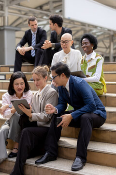 Business teamwork concept, Businessperson brainstorm colleagues discussing ideas and using tablets together while sitting outdoors in corporate setting. teamwork, business, collaboration, tablet.