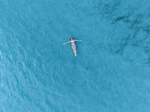 Woman floats in turquoise sea during summer vacation