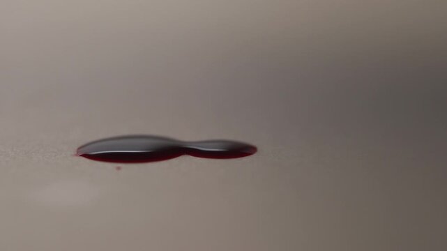 Red blood pool dripping in slow motion, side view zoom in off-center left, tense dramatic vibe for crime scene and horror movie B-roll⁠