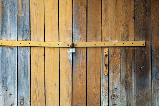 Weathered wooden door secured with a simple metal latch