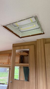 Unfinished caravan ceiling roof vent installation showing wiring inside a wooden camper interior