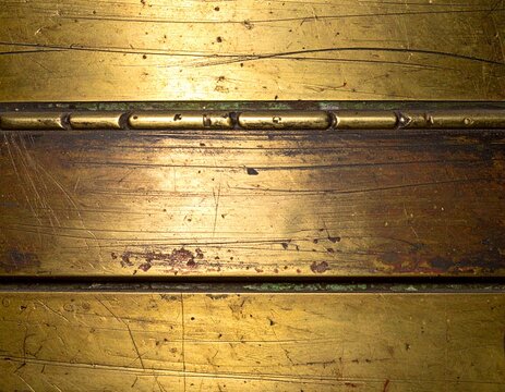 Rusty metal surface with scratches and scratches with hinges on old wooden table