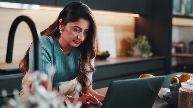 Woman, laptop and research in home for remote work, website or editing with productivity. Freelancer, pc and search online with feedback, proofreading and workflow for creative report in kitchen