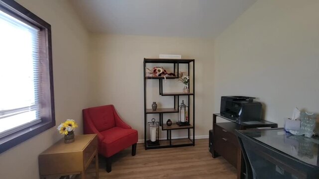 Cozy home office scene with red armchair and wooden bookshelf