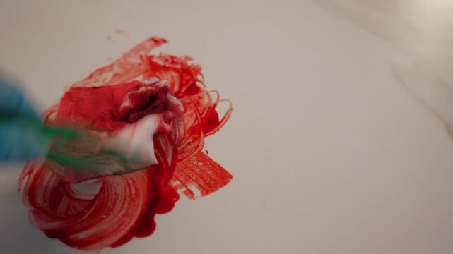 Green disposable forceps wiping blood stain in circular motion with tissue on left side, 45 degree macro view, right copy space for forensic analysis B-roll