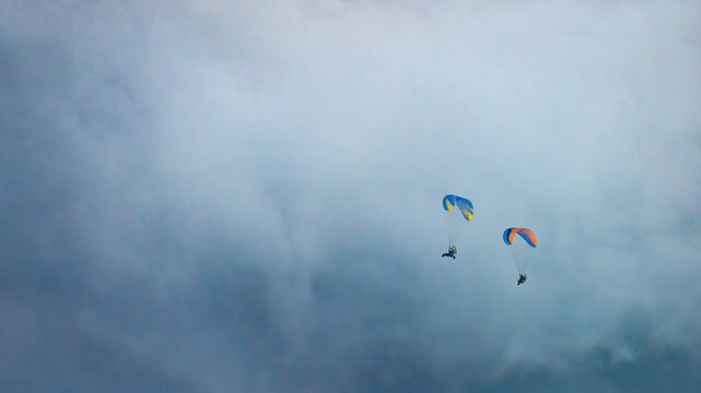 Sportsman flying with motorglider through dark clouds enjoying adrenaline
