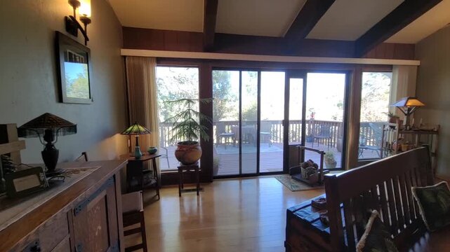 Sunfilled Living Space With Sliding Doors Opening To Picturesque Deck And Outdoor Landscape