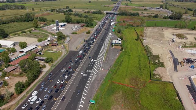 Aerial drone view of a long traffic queue on a major highway leaving Milan, showing heavy congestion and the impact of peak travel on Italian road transportation.